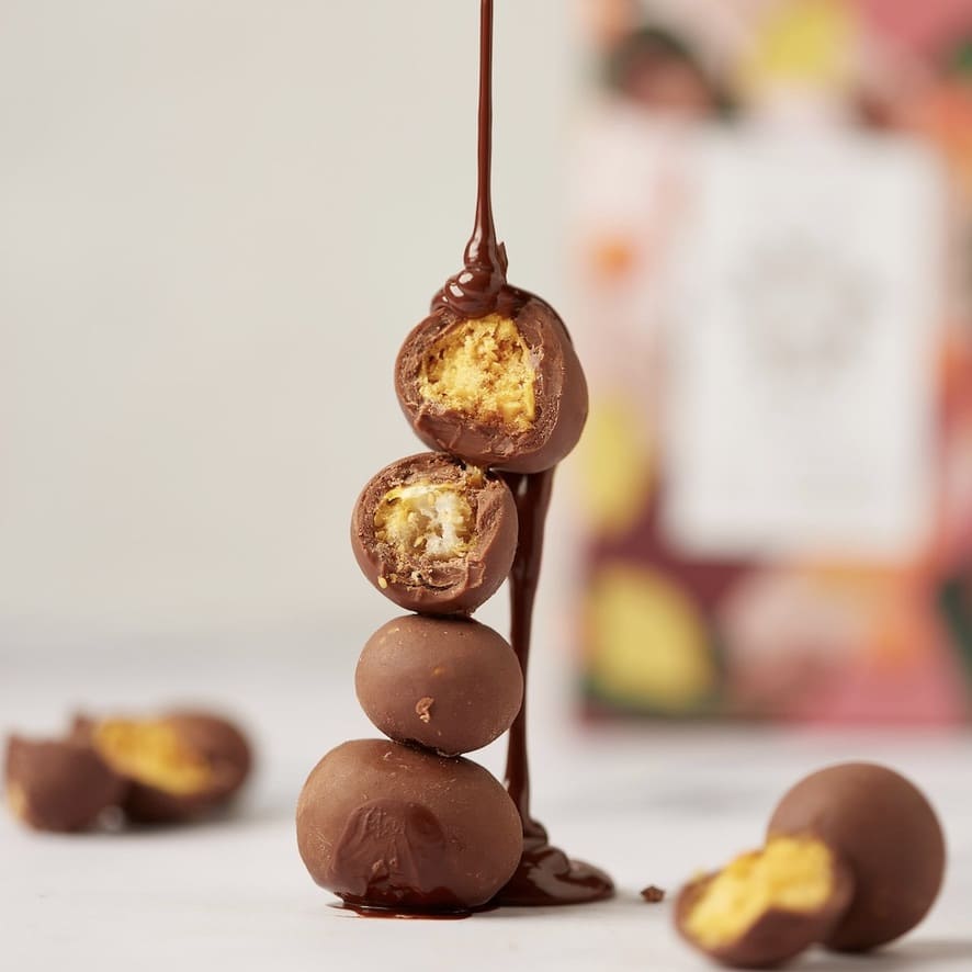 4 Frutas tropicales cubiertas de chocolate de leche, con chocolate derretido sobre ellos 